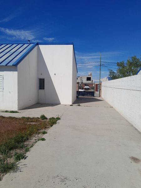 Entrada de auto y costado de la casa