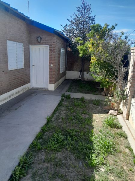 Patio lateral con jardín junto a la pared de ladrillo